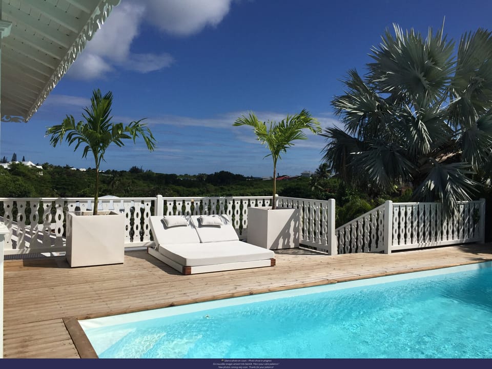 Spacious outdoor terrace with pool and sun loungers, ideal for enjoying the sun and sea views in Saint-François.