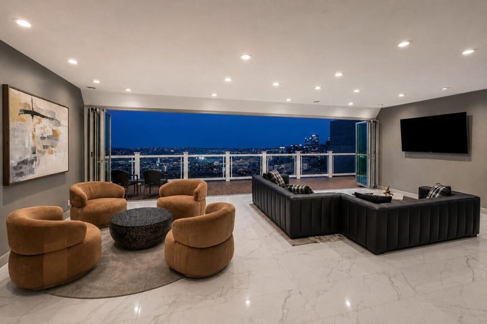 Bright, open-plan living area with floor-to-ceiling windows and seamless access to the private patio, perfect for relaxing with skyline views
