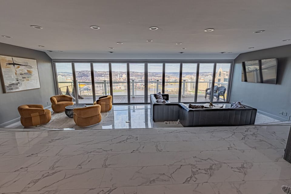 Bright, open-plan living area with floor-to-ceiling windows and seamless access to the private patio—perfect for relaxing with skyline views.