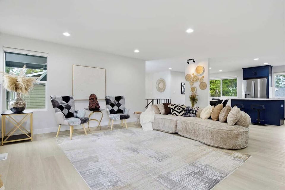 Open-concept living room with designer furnishings and kitchen