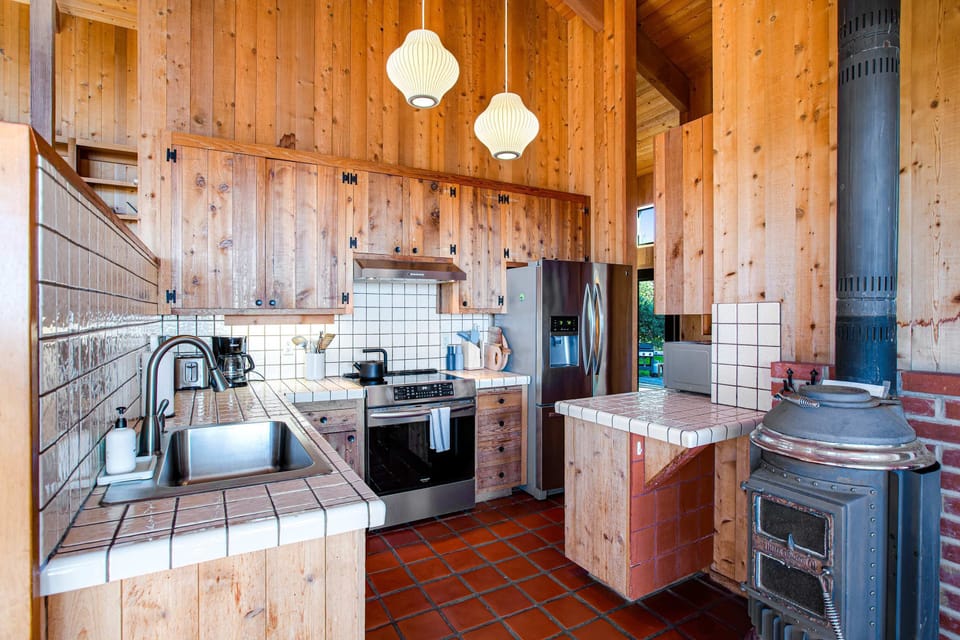 Enjoy gathering around the spacious kitchen, complete with a cozy wood stove, perfect for warming up after a day by the beach.