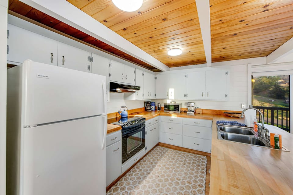 Craft delicious meals in this inviting kitchen, where modern amenities meet charming coastal decor for an enjoyable cooking experience.
