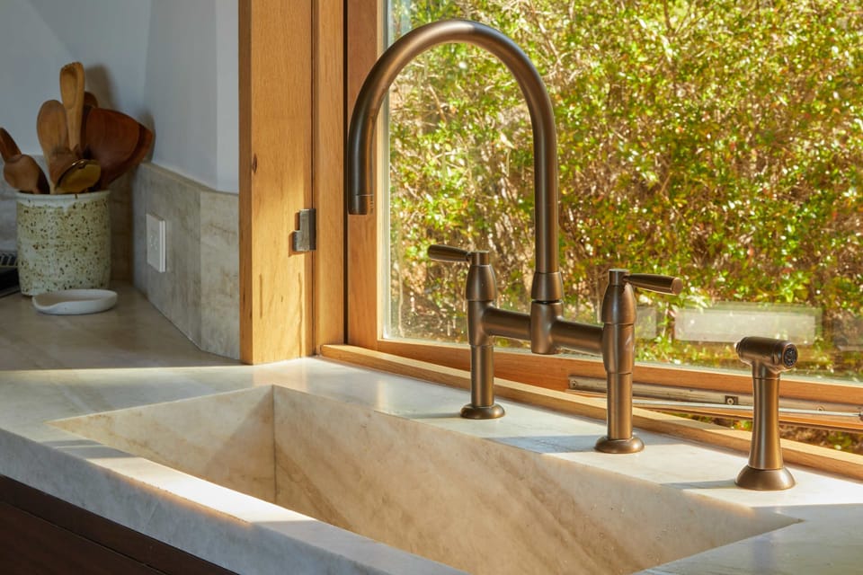 Experience the joy of cooking in this beautifully designed kitchen sink area, where natural light enhances your meal prep with a refreshing view of nature.
