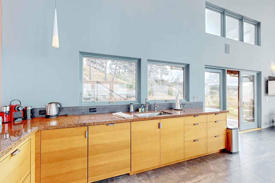 Step into a kitchen that combines modern design with coastal charm, providing a wonderful space for culinary creativity and entertaining.