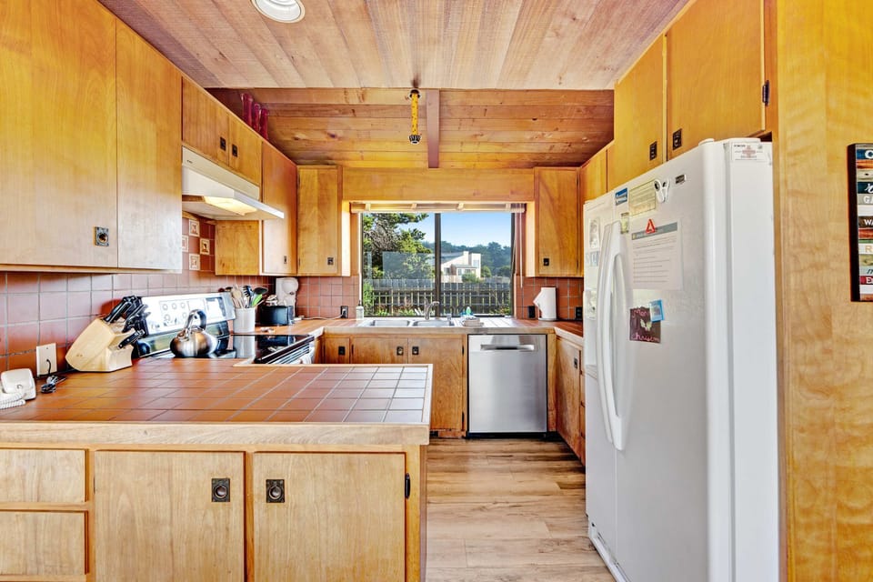 Unleash your inner chef in this well-equipped kitchen, where you can prepare family meals while enjoying the stunning coastal scenery outside.