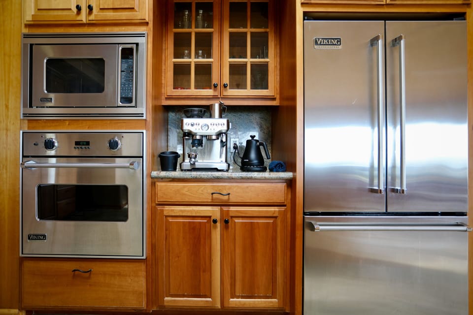 Morning espresso from the built-in Breville station — the Viking wall oven and French-door fridge handle everything from brunch to dinner parties.