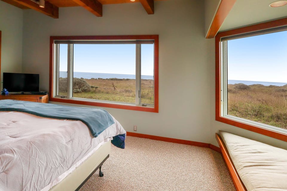 Your private oasis awaits in this inviting primary bedroom, featuring a cozy corner for reading while absorbing the tranquil scenery.