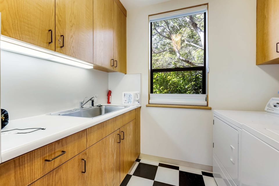 This functional kitchen area features ample space for meal prep and laundry, ensuring your stay is both comfortable and convenient.