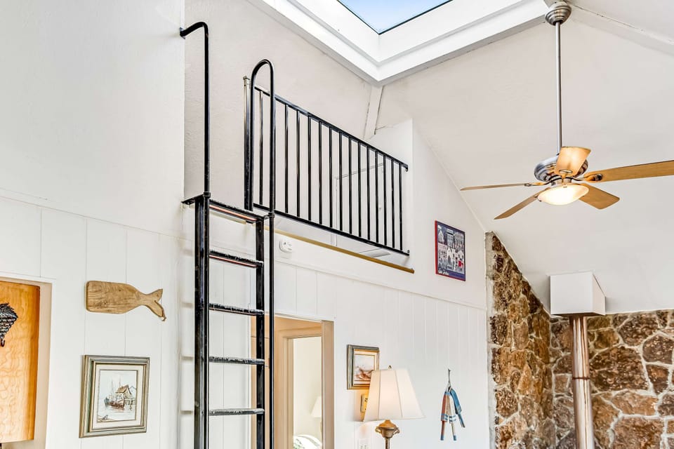 A charming staircase leads to a cozy loft space, perfect for extra guests or a creative retreat away from the main living area.