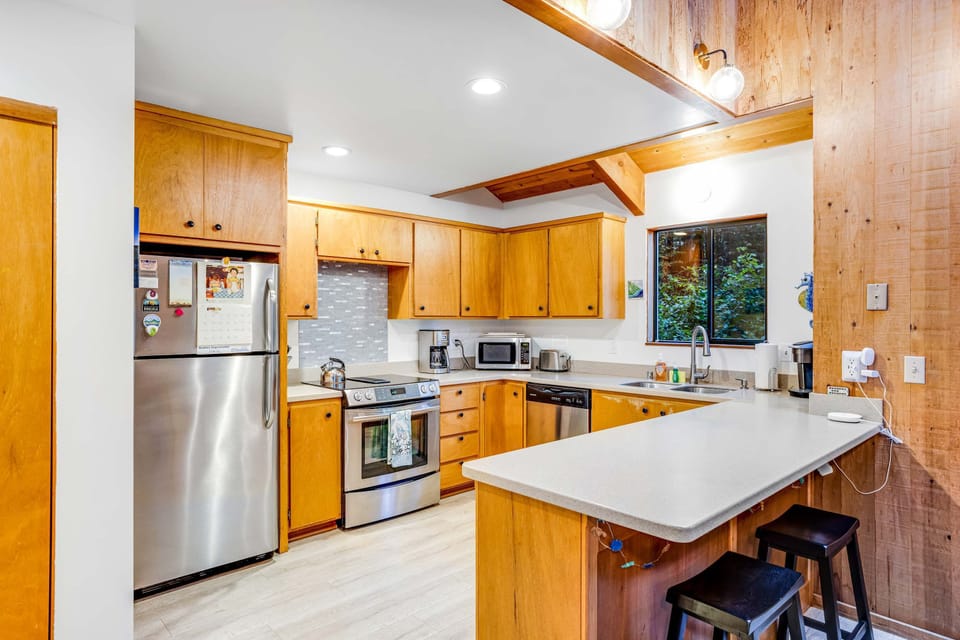 Gather around the breakfast bar for morning coffee and casual chats in this welcoming kitchen, where nature’s beauty is just a glance away.