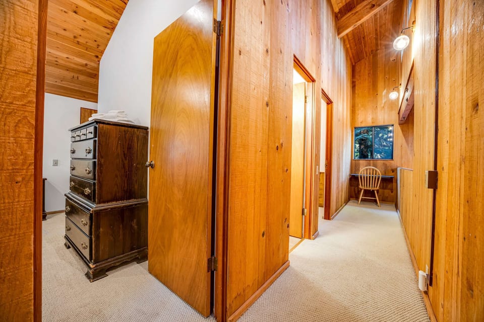 Step into the warm corridor, where natural wood accents create a welcoming flow and lead you to your cozy sleeping quarters.
