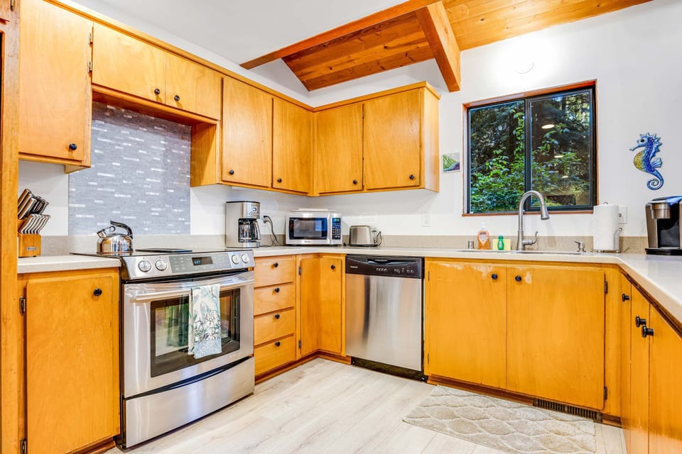 Cook up delicious memories in this bright kitchen, featuring modern amenities and a view of the lush outdoors that inspires creativity.