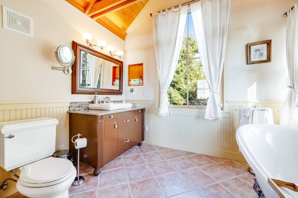 Indulge in a spa-like experience in this elegant bathroom, flooded with natural light and featuring a classic soaking tub.