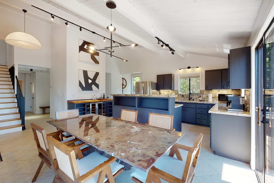 The modern dining area invites you to gather for meals, offering an elegant space that seamlessly blends with the stunning outdoor views.