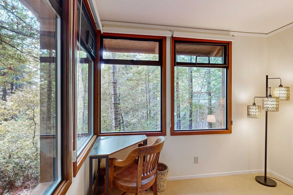Settle into this cozy workspace, where natural light and the calming forest view inspire creativity and focus.