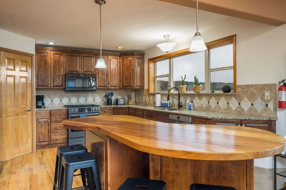 Full kitchen with granite counters and a live-edge breakfast bar