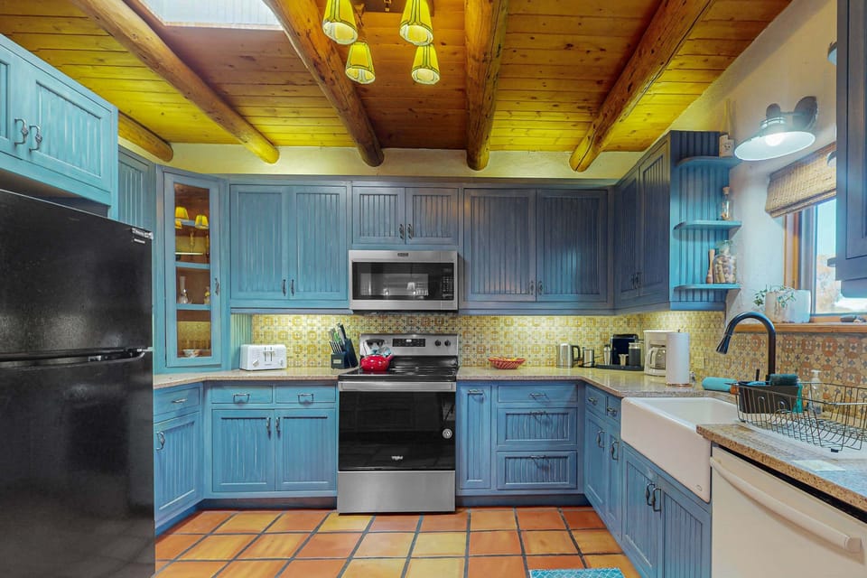 A cheerful blue kitchen with farmhouse sink and dishwasher