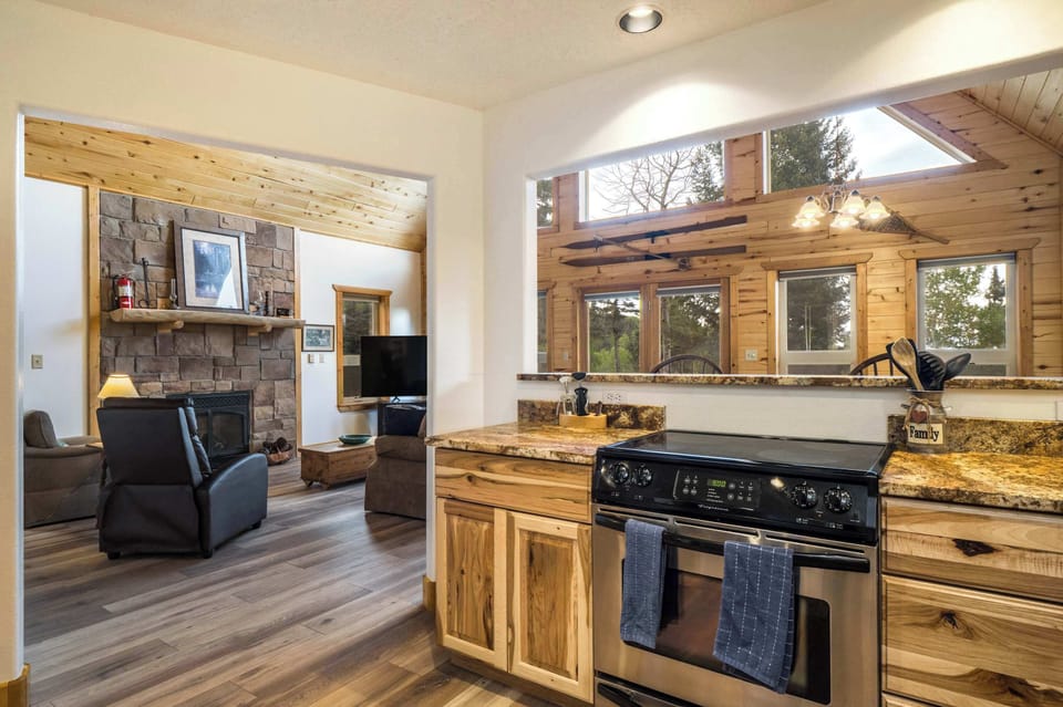 Cook on the full range with granite counters and forest views
