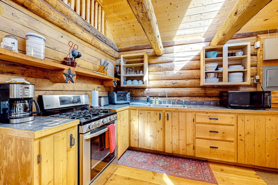 Cook in the full kitchen with a gas range and open shelving