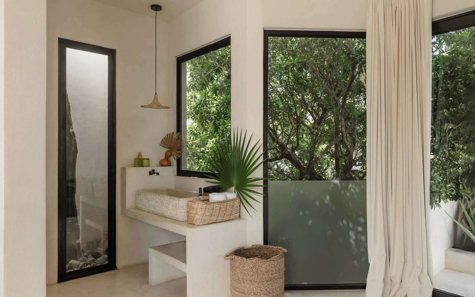 Warm wood accents and lush garden views just steps from the vanity.