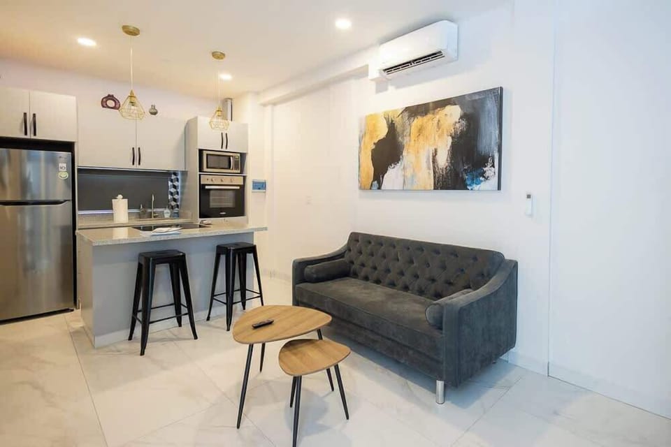 Bright living area w/ sofa, TV & breakfast bar for easy lounging