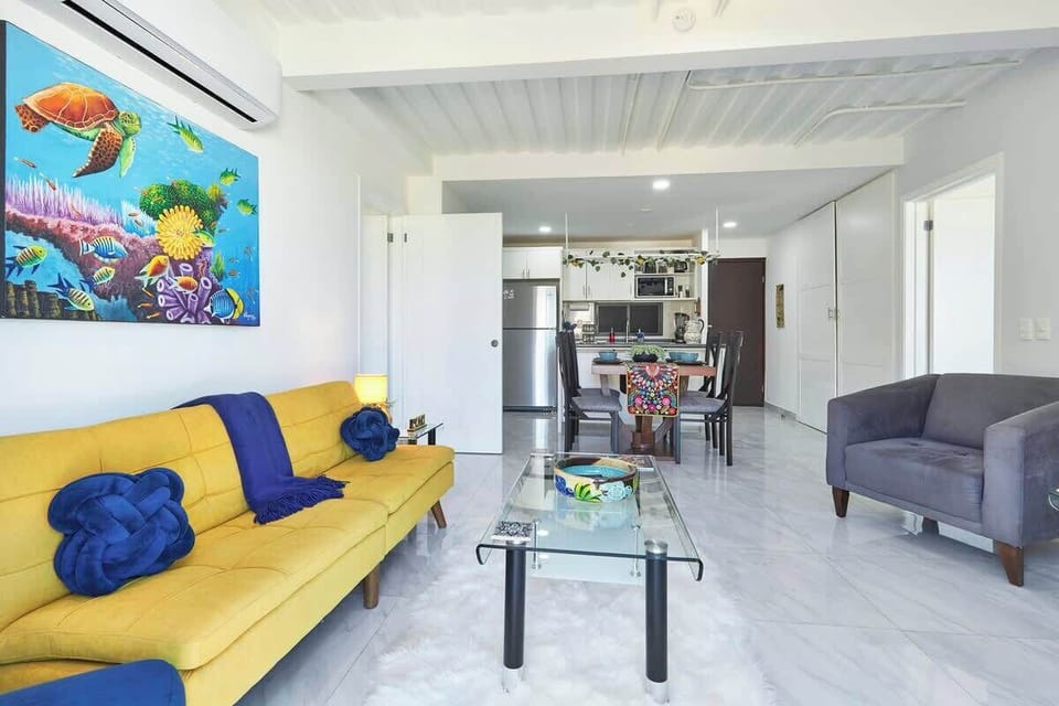 Open living room w/ vibrant sofa, wall art & relaxed seating