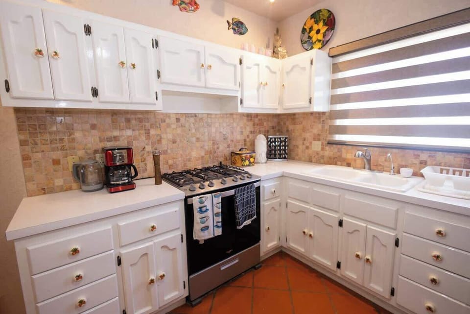 Functional kitchenette w/ ample cabinets, stove & prep space