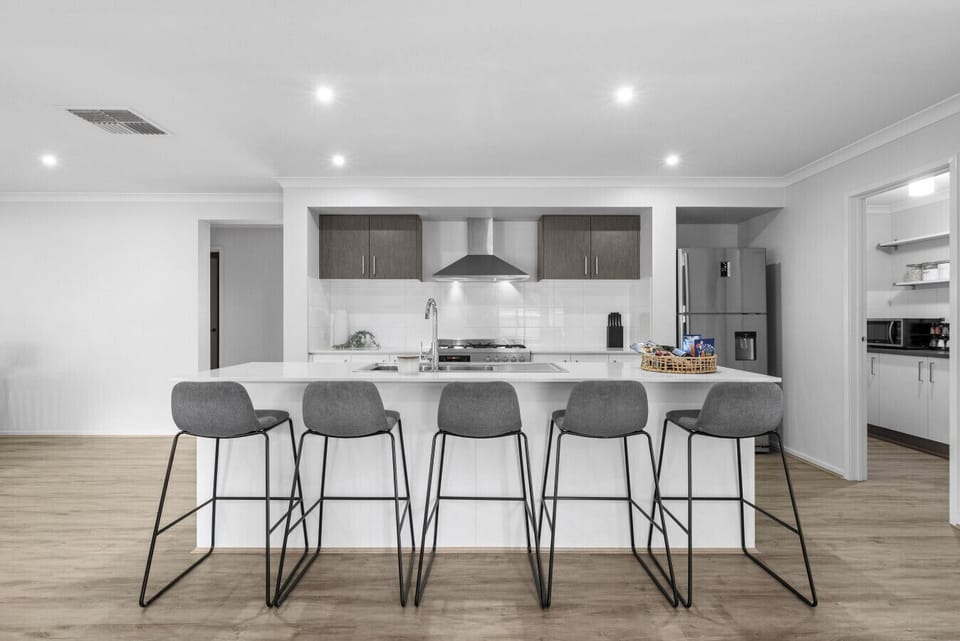 Modern kitchen featuring a large breakfast bar and ample seating.
