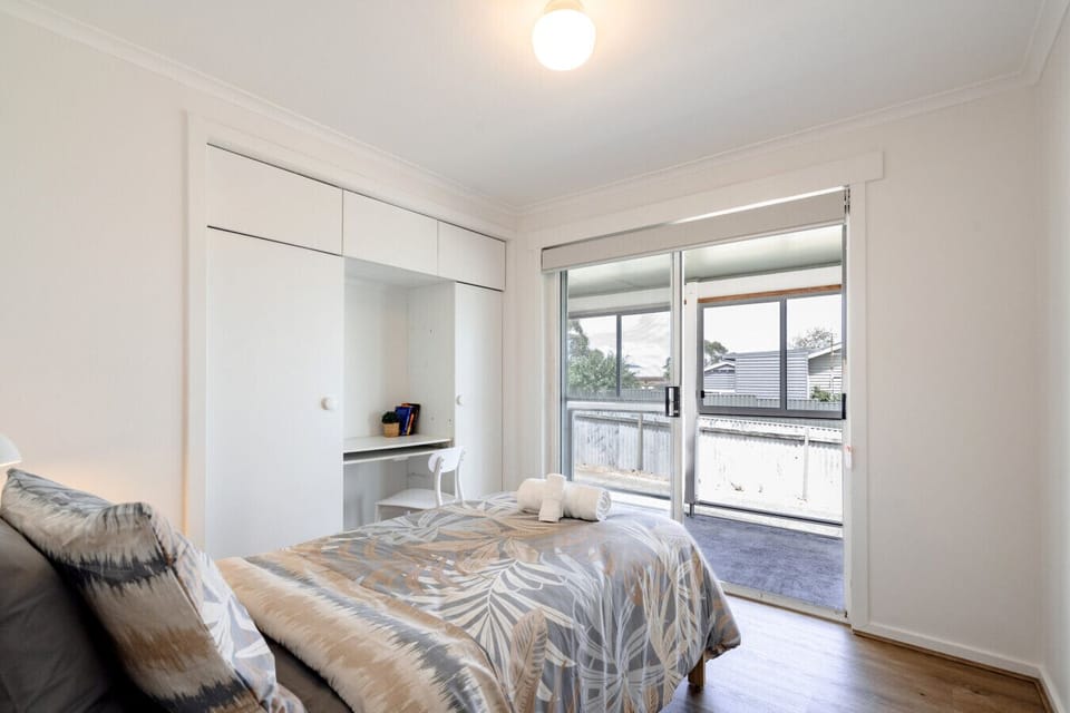 Bedroom 3: Bright bedroom featuring built-in storage and direct balcony access.
