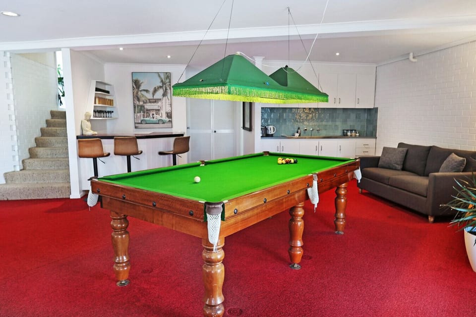 Entertainment room with pool table, lounge seating, and bar area