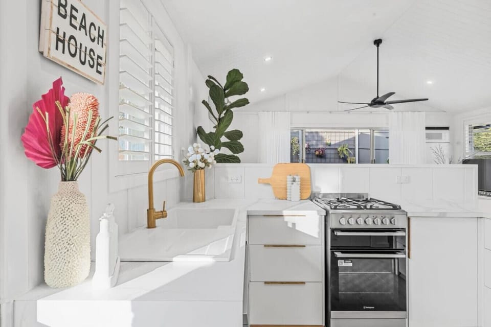 Marble benchtop, brushed gold tap, and gas stove — fully equipped.