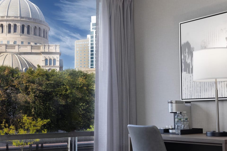 Wake up to bright city views beside a cozy desk.