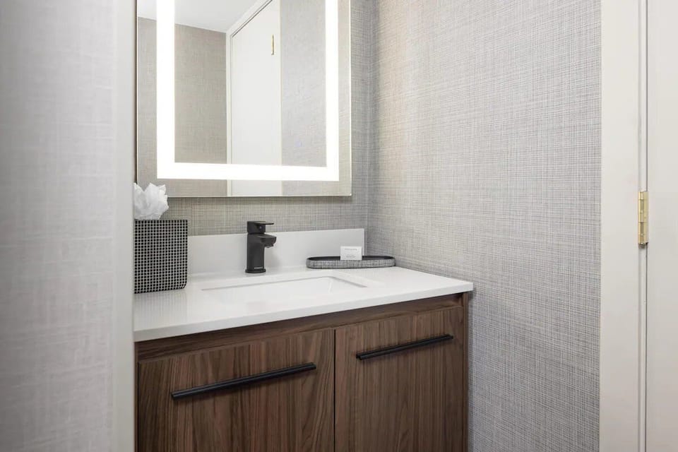 Refresh at a sleek vanity with glowing mirror light.
