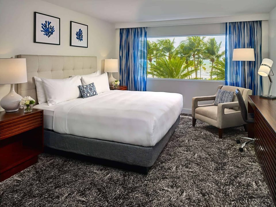 Unwind in a serene room with breezy tropical window views.