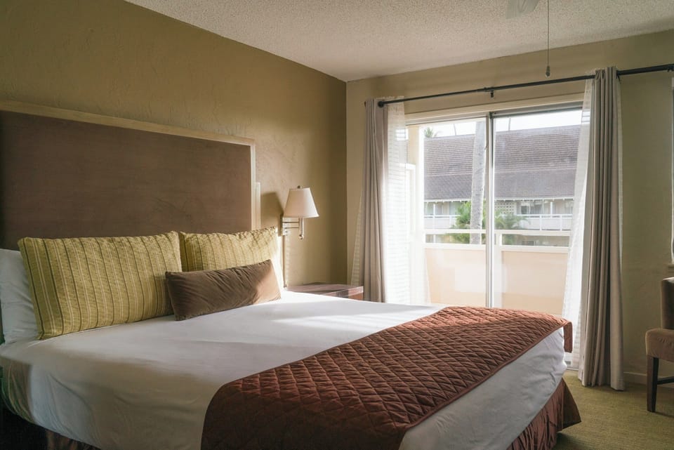Unwind in a sunlit bedroom with soft linens and calm views.