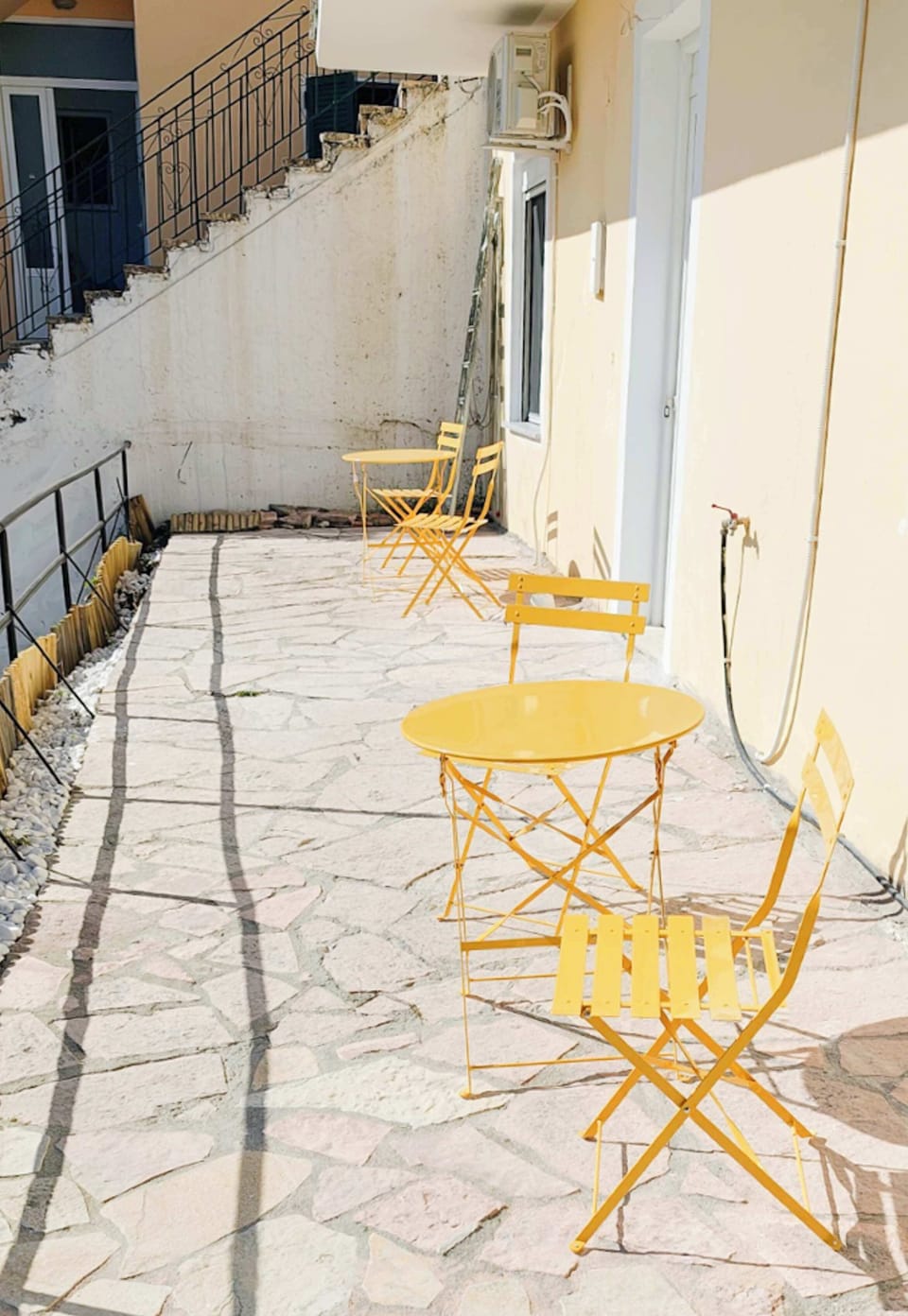 Private outdoor space with charming yellow table and chairs.