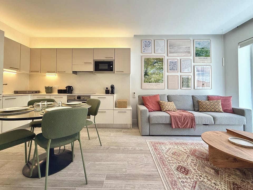 Living area equipped with a sofa bed, a flat-screen Cable TV for entertainment and a balcony.