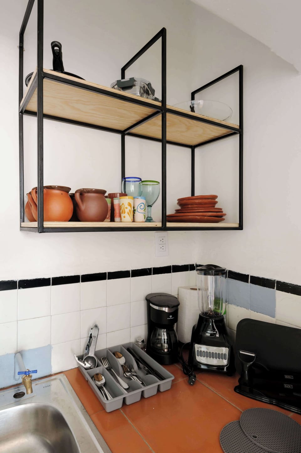 Kitchen with cookware, utensils, blender, stove and more