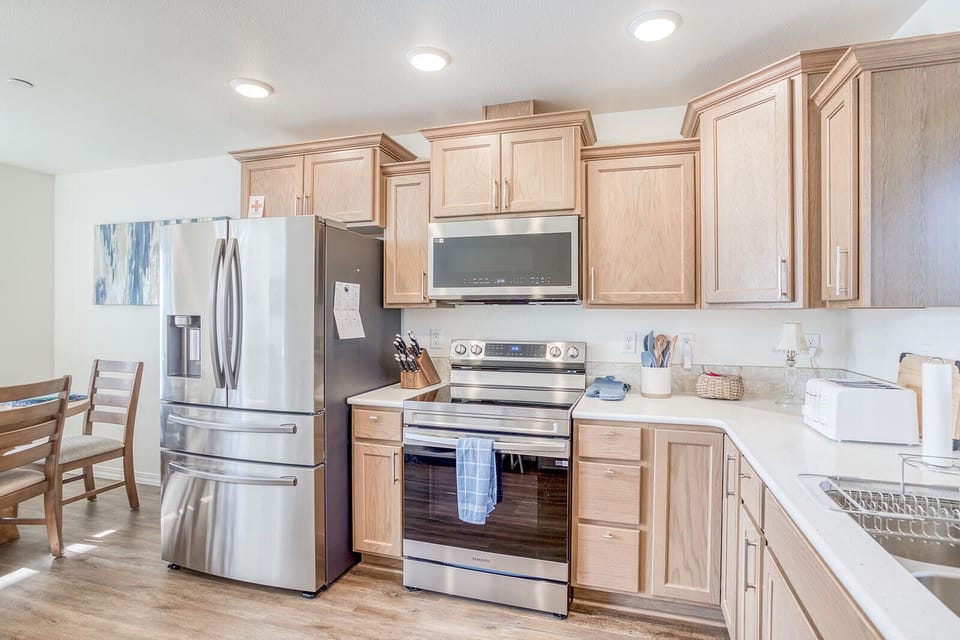 Your fully equipped kitchen features warm wood cabinetry, stainless steel appliances, and ample counter space for creating memorable meals together.