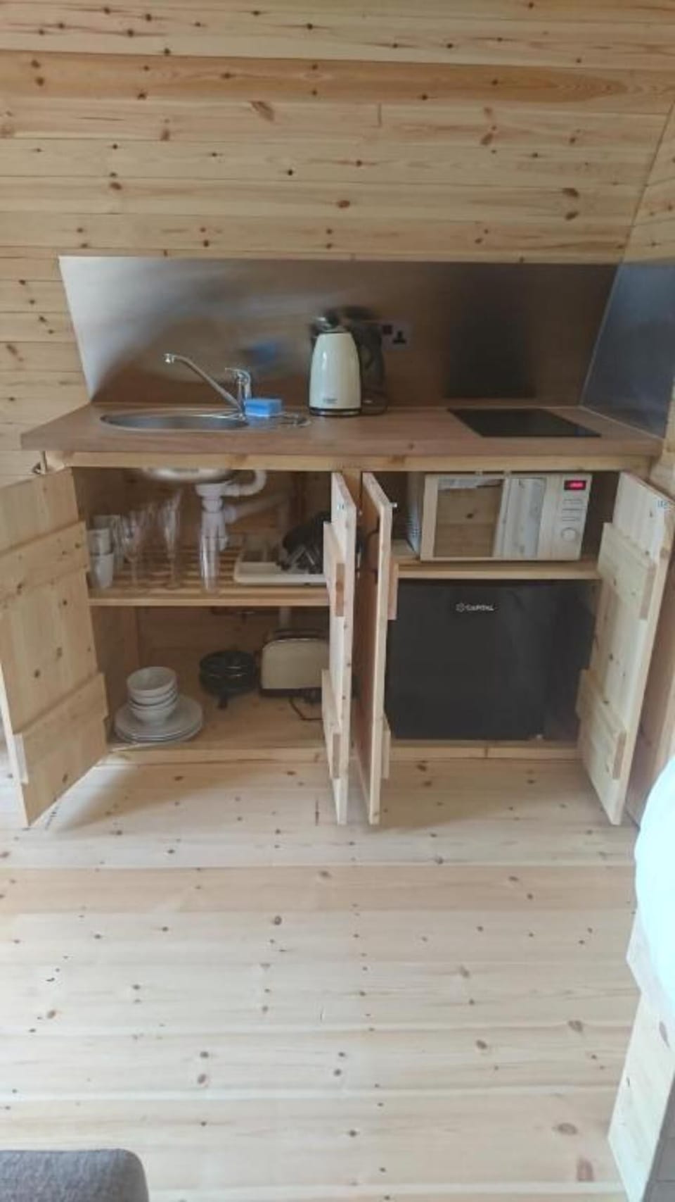 Pods are equipped with glasses, cups, utensils, plates, cutlery, pots and frying pan.  Microwave, toaster, kettle, small fridge and electric 2 ring hob.