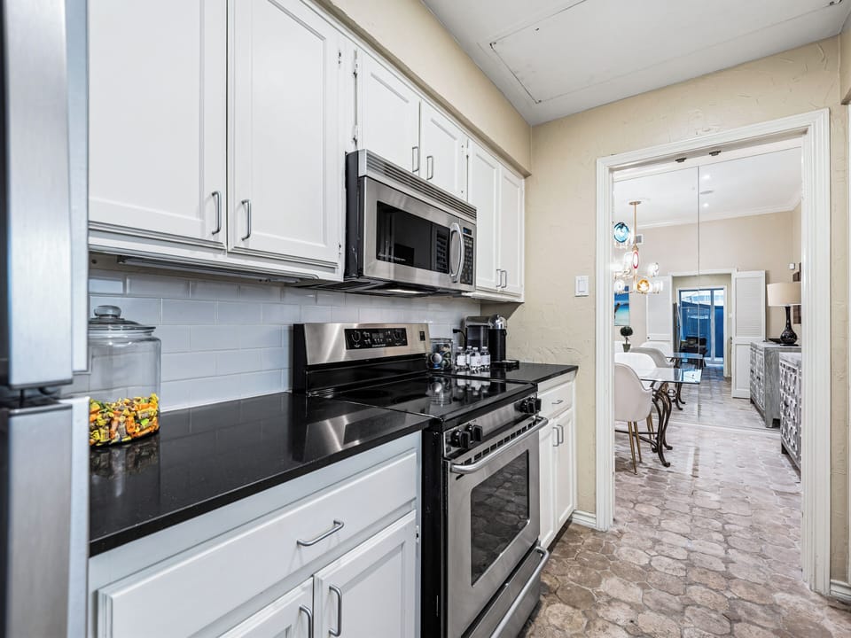 Cook your favorite meals in this fully equipped kitchen with modern appliances and sleek granite countertops.