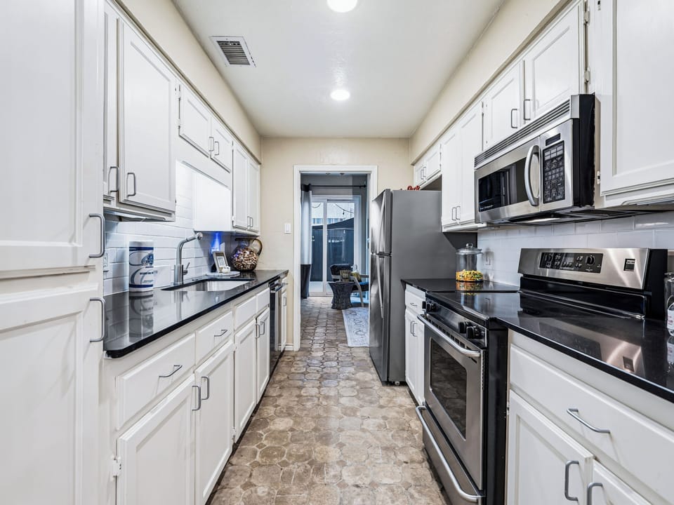 Your fully equipped galley kitchen features stainless steel appliances, granite counters, and white cabinetry for effortless meal preparation.