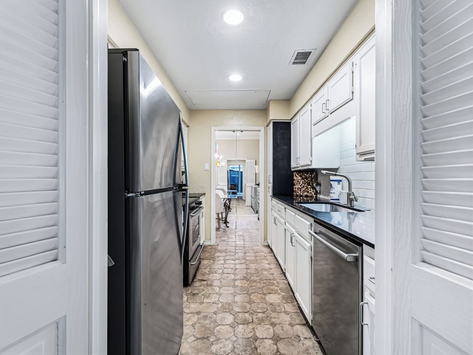Your sleek galley kitchen features modern stainless steel appliances and crisp white cabinetry, perfect for preparing memorable meals during your stay.