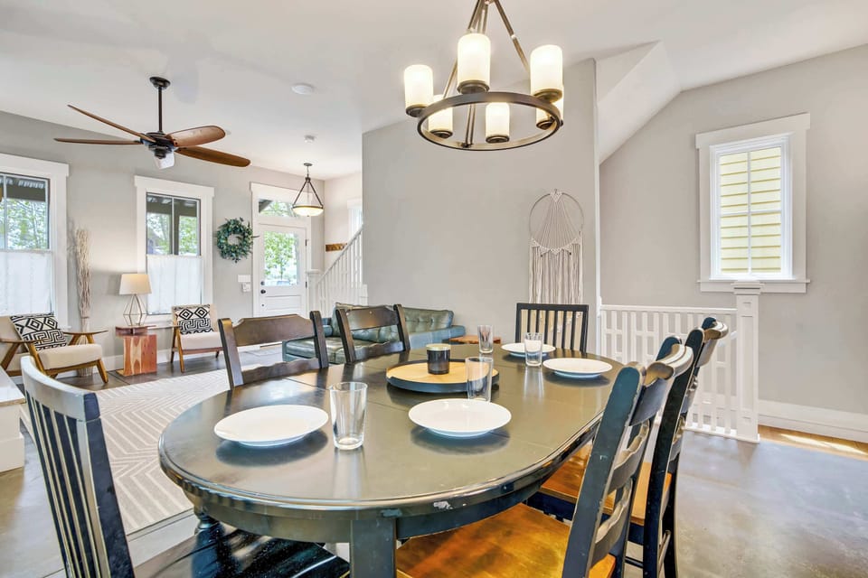 The dining area brings everyone together around a large dark oval table beneath a candle-style chandelier, with seating for six and the warmth of the living room just steps away, ideal for group dinners after a day on the river.