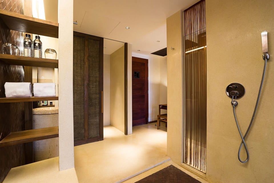 Refresh under the rainfall shower in a serene spa setting.