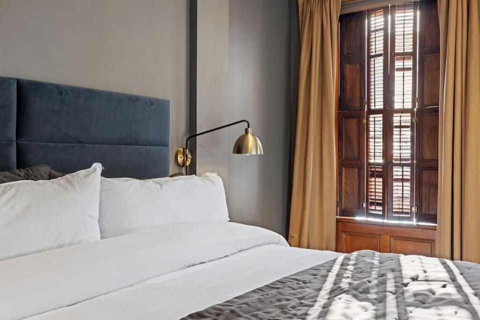 Relax in soft bedding as warm light filters through shutters.