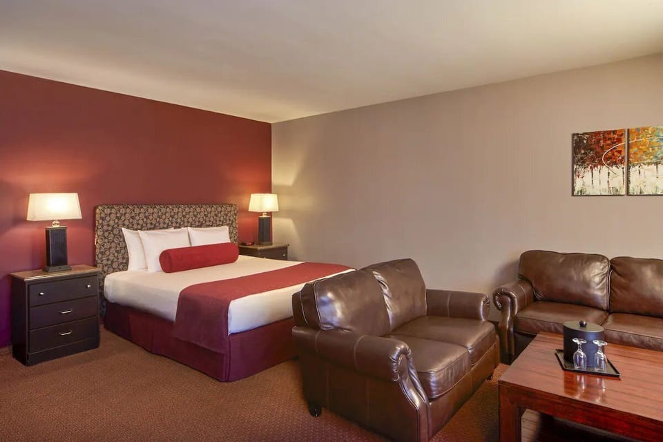 Unwind in a cozy king bed beside lounge seating.