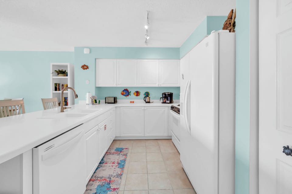 Your fully equipped kitchen features bright white cabinetry and modern appliances, perfect for preparing meals during your stay.