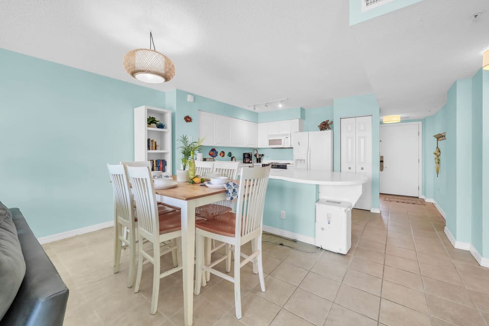 Gather around your stylish dining table in this open-concept space, where coastal-inspired colors and modern comfort create the perfect backdrop for memorable meals.