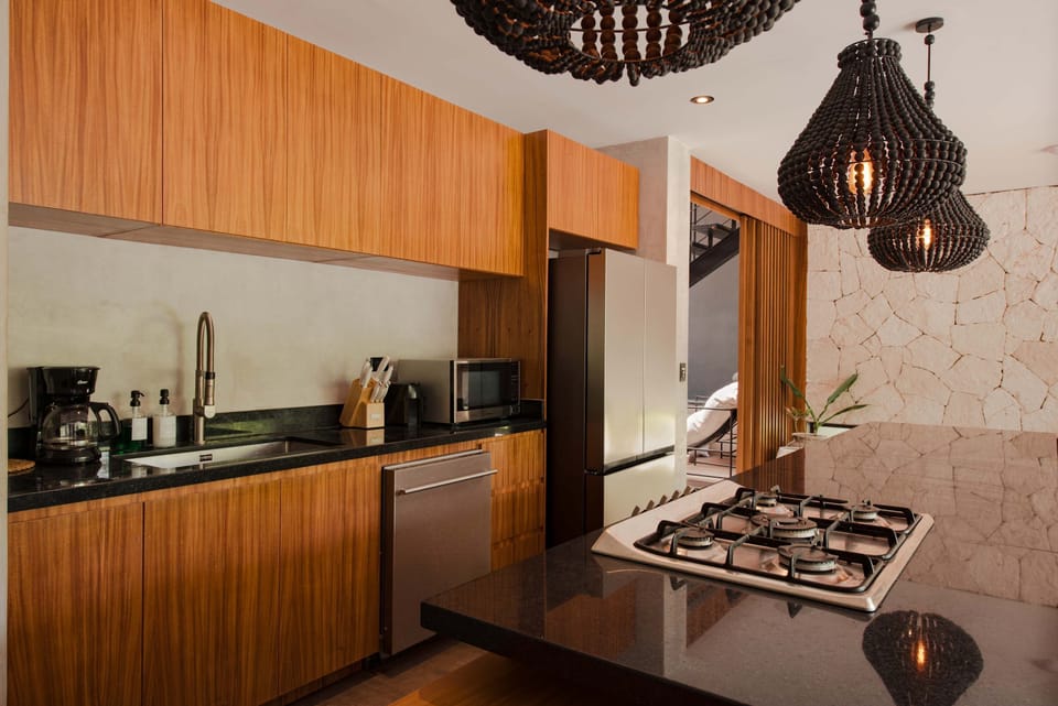 Gourmet kitchen with dark stone countertop, warm wood cabinetry, and premium appliances.